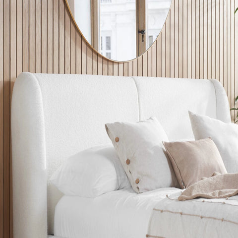 Curved bouclé headboard with soft padded cocoon design.
