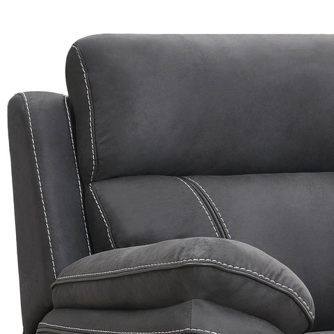 Close-up of a dark gray upholstered chair or recliner with white contrast stitching, showing the backrest, armrest, and cushion against a plain white background.