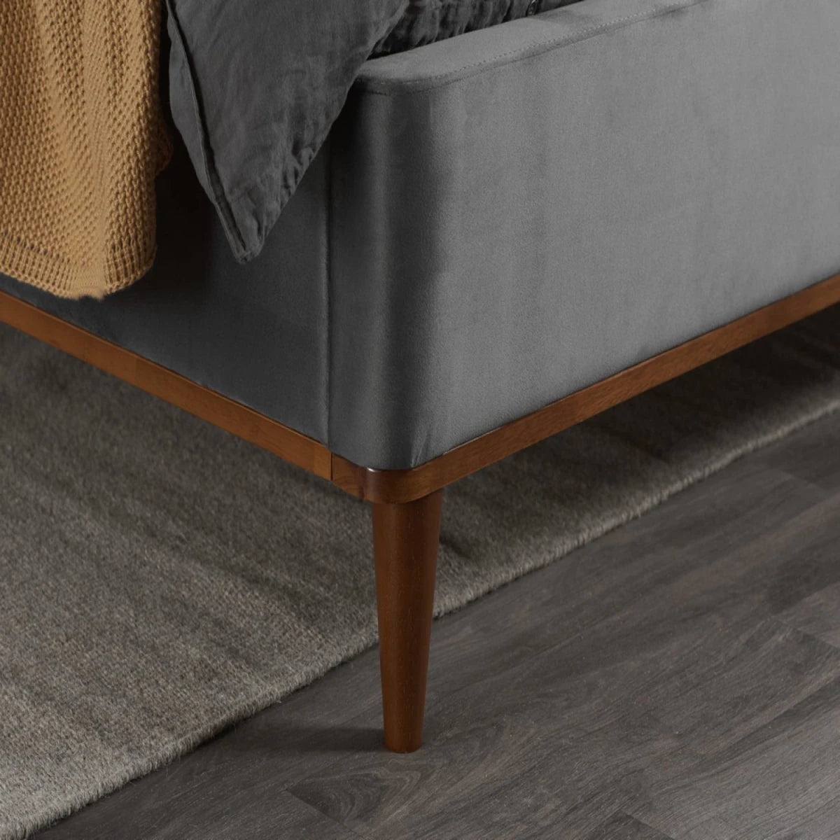 Sturdy support feet for velvet upholstered bed frame.
