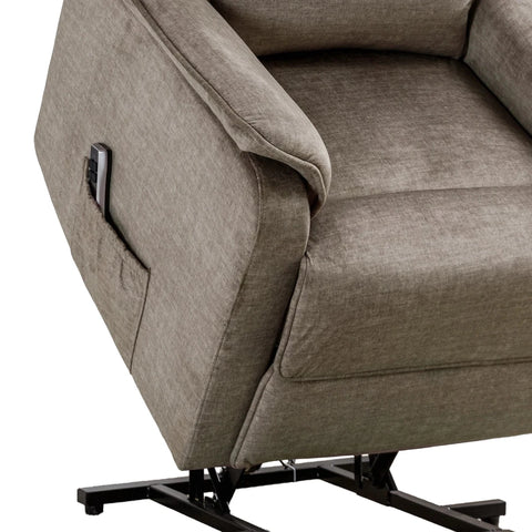 Close-up of a upholstered recliner chair in a warm taupe-gray fabric, showing the side pocket with a remote control and part of the black metal base against a white background.