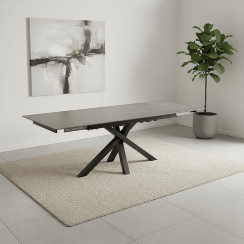 Modern Brando Samurai dining table with extending leaves in a minimalistic room with abstract art and a plant.