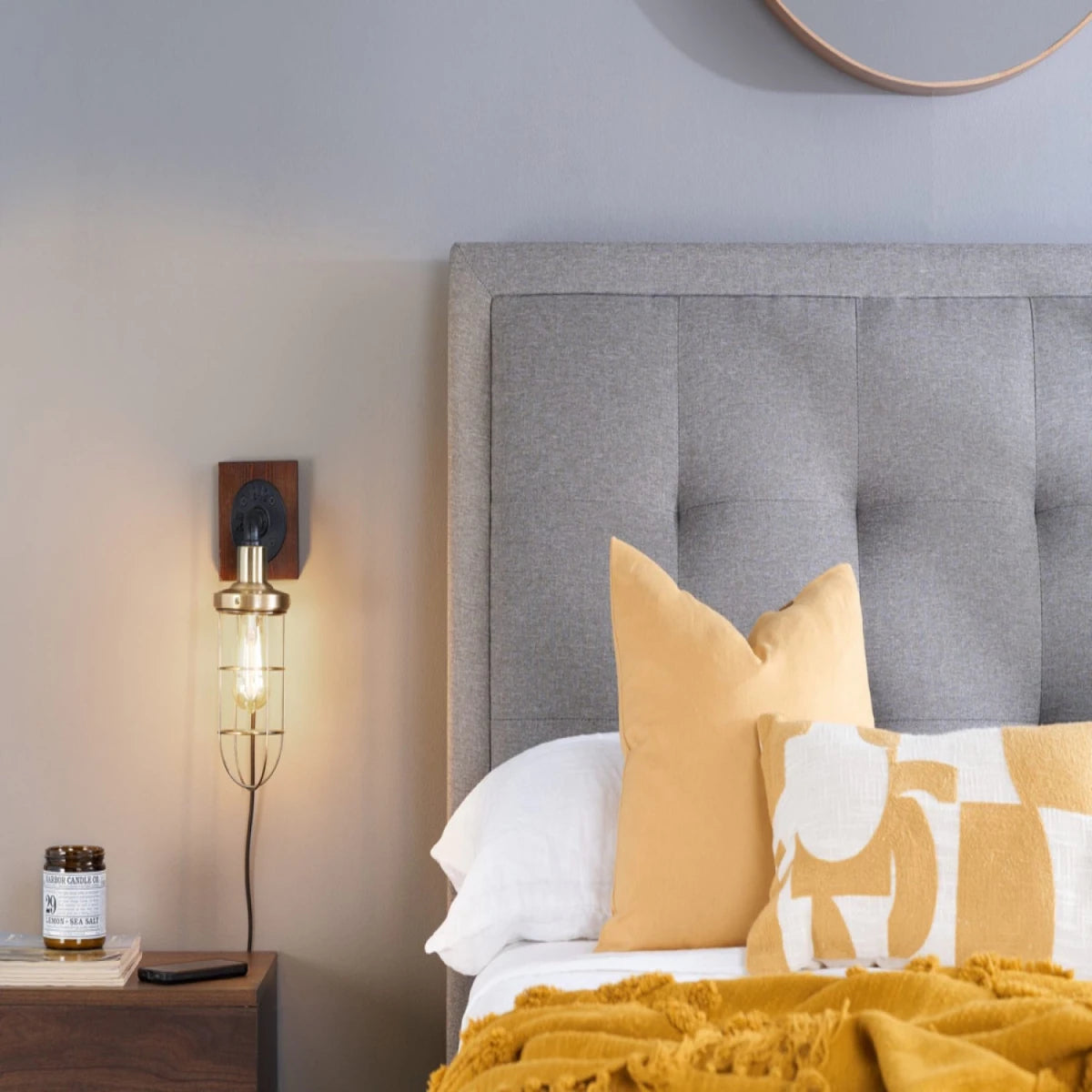 Grey upholstered headboard with refined button detailing.