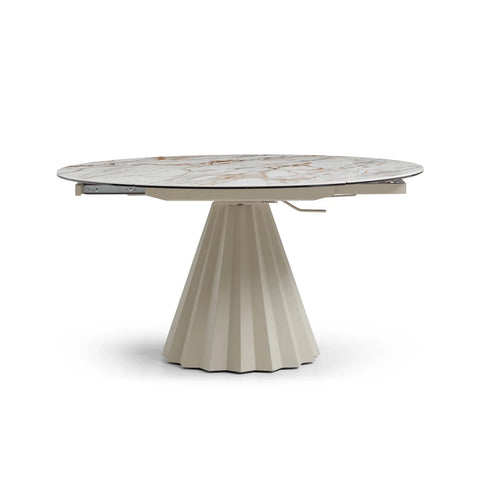 Round dining table with marble top and pleated base on a white background