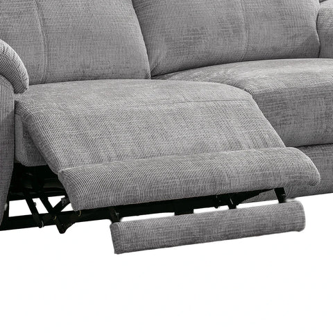 Close-up of a gray textured reclining sofa with the footrest extended, showing the fabric texture and black reclining mechanism against a white background.