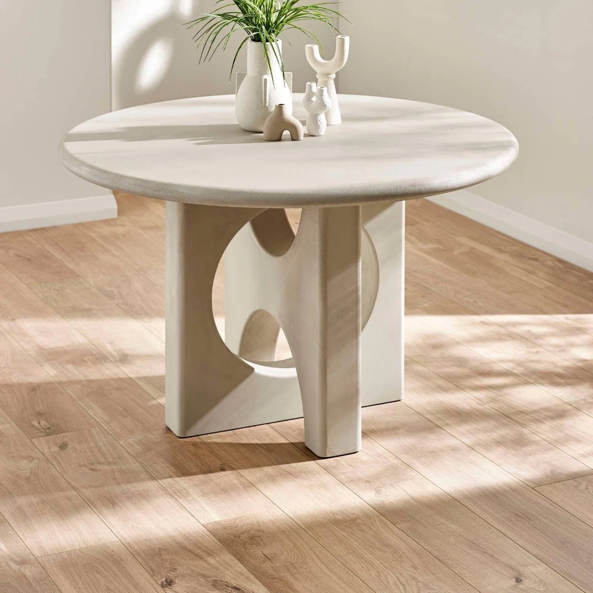 Shop the Thyro 120cm Round Concrete Effect Dining Table. Featuring a sculptural arch pedestal base and contemporary stone-inspired finish. Seats 4.