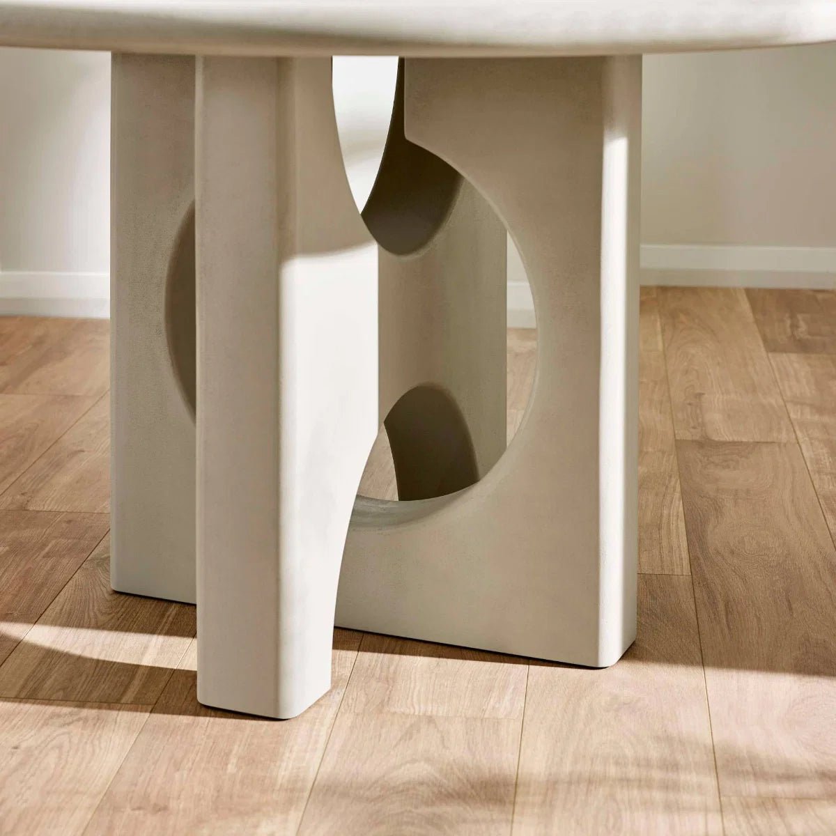 Base Close up of Thyro 120cm Round Concrete Effect Dining Table. Featuring a sculptural arch pedestal base 