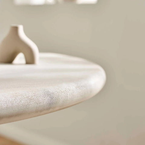 Table top close up of Thyro 120cm Round Concrete Effect Dining Table. Featuring a sculptural arch pedestal base 