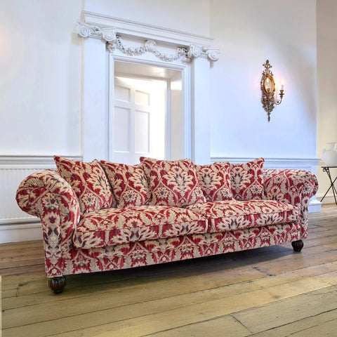 Red and beige patterned elgar sofa in a room with wooden flooring and white walls
