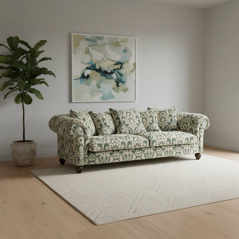 Tetrad Elgar Grand Sage and Beige Patterned sofa with decorative pillows in a living room setting.
