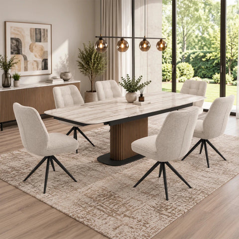 A modern dining room set featuring a rectangular Umbria Travertine Ceramic Dining Table with a fluted pedestal base and six julio ivory upholstered swivel chairs in a light beige fabric with black metal legs, arranged on a textured beige rug.