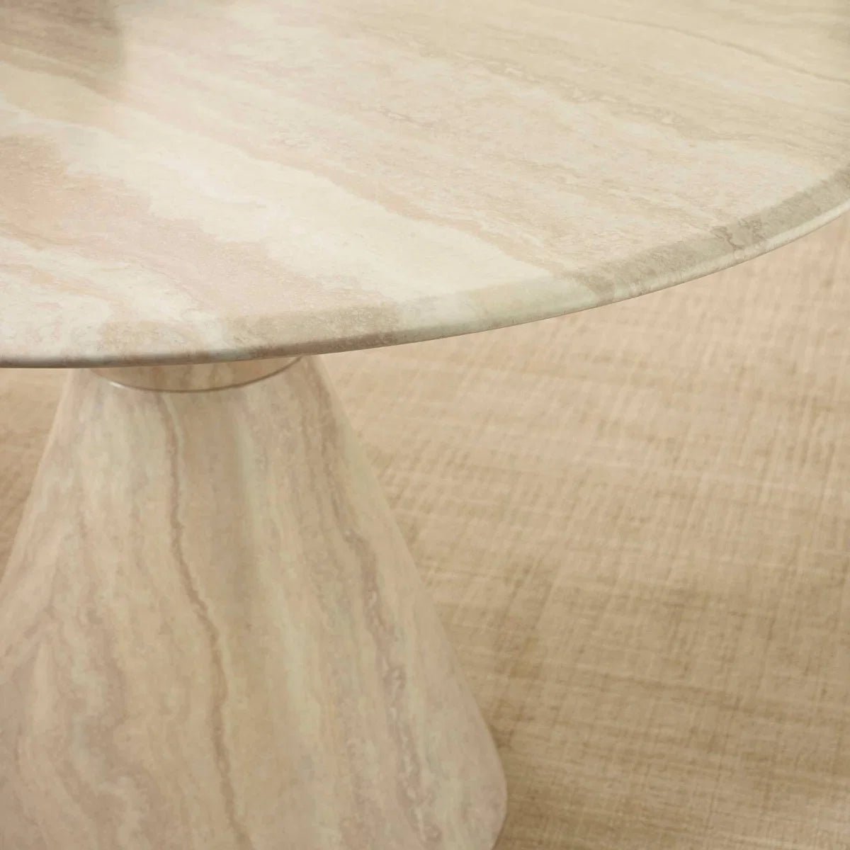 Close up of Vero 120cm Round Cream Marble Effect Dining Table. Featuring a sculptural pedestal base 