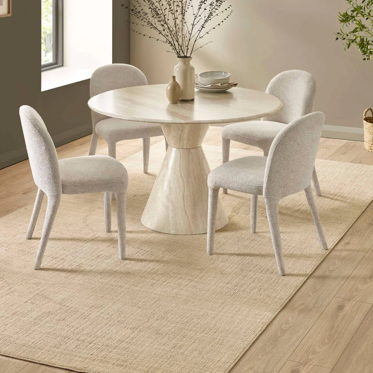 Vero 120cm Round Cream Marble Effect Dining Table. Featuring a sculptural pedestal base  and fabric chairs