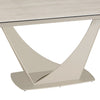 A close-up of a modern dining table showing a light travertine tabletop and a sculptural, curved pedestal base in a warm beige finish, set against a plain white background.