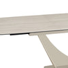 Close-up of a modern extendable dining table with a light beige travertine ceramic  top and a matching sculptural pedestal base on a white background.