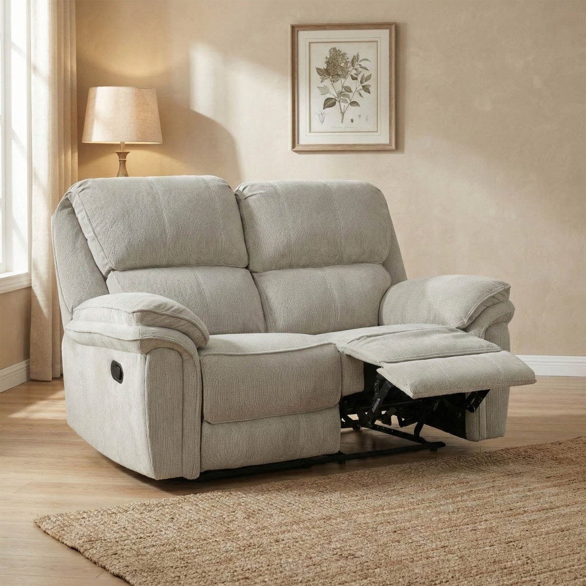 Beige 2 Seater recliner sofa in a living room setting with a lamp and framed picture on the wall.