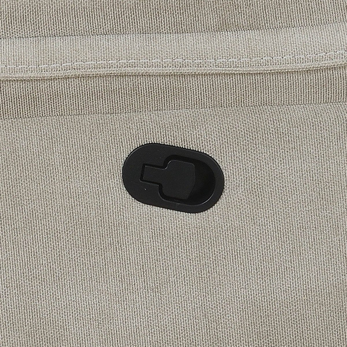 Close-up of a light beige textured fabric sofa with a black oval plastic hook-and-loop fastener.