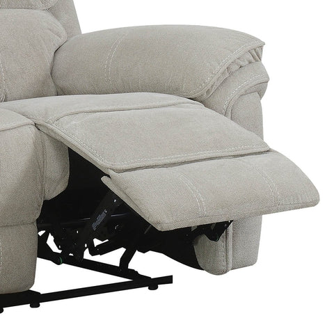 Close-up of a light beige upholstered recliner chair with the footrest extended, showing the fabric texture and support mechanism against a white background.