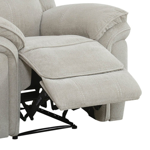 Close-up of a light beige upholstered recliner chair with the footrest extended, showing the fabric texture and black support mechanism against a white background.