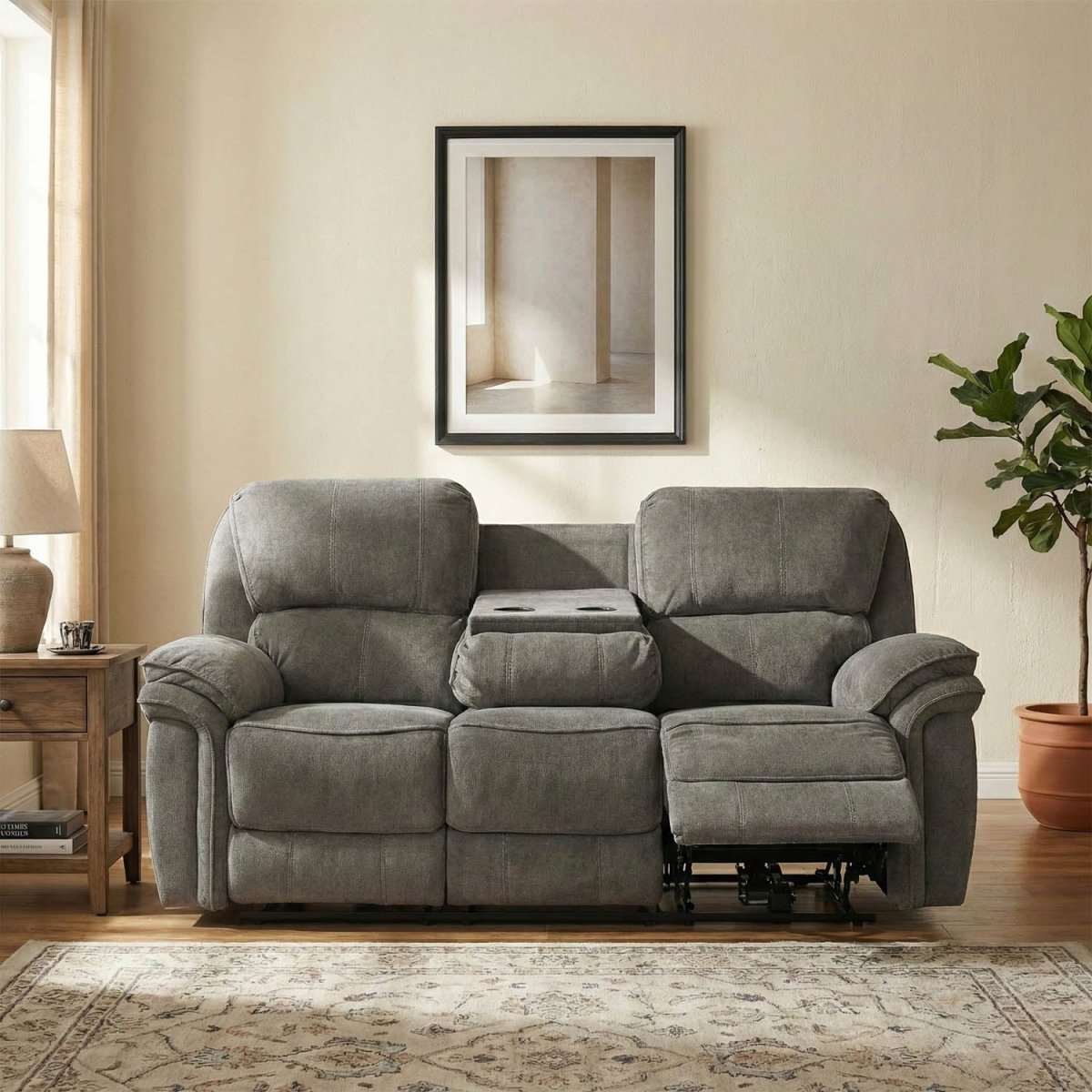 Gray recliner sofa in a living room setting with a framed picture and plant.