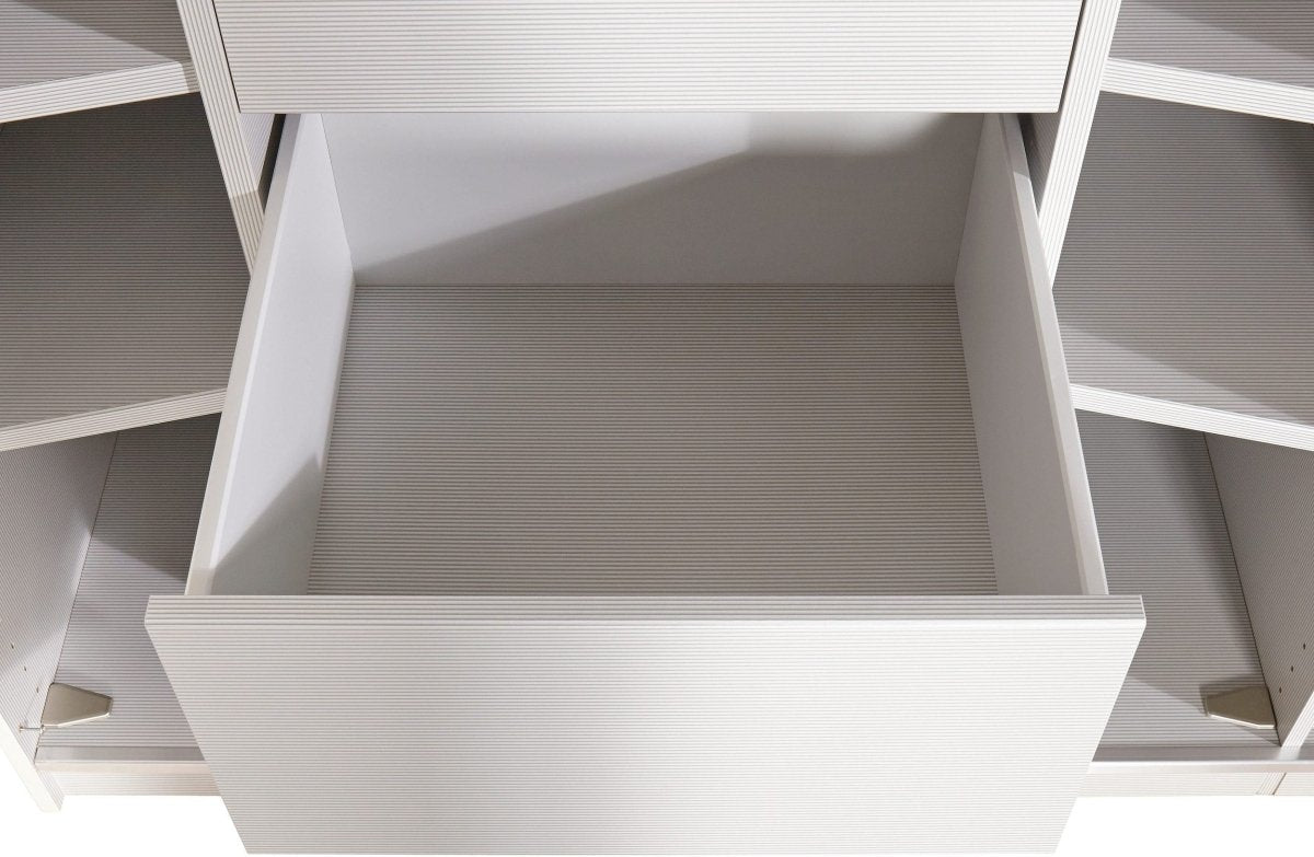 A close-up view of a white drawer pulled open within a matching white storage cabinet or shelf unit.