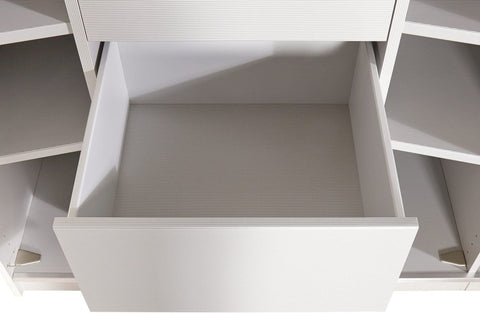 A close-up view of a white drawer pulled open within a matching white storage cabinet or shelf unit.