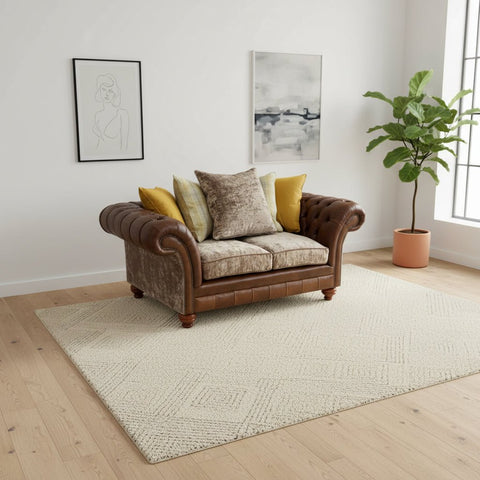Brown leather sofa with patterned cushions against a rustic brick wall.